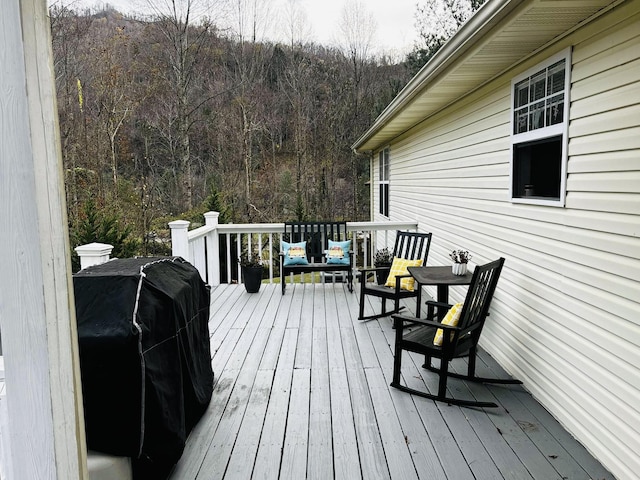 wooden deck with a grill and a view of trees