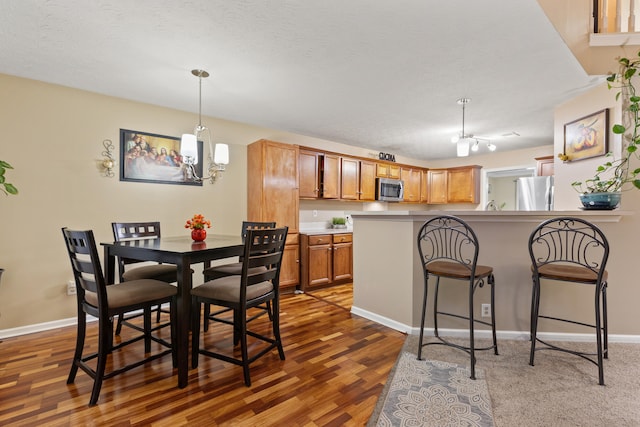 dining room featuring dark wood-style floors, baseboards, and a textured ceiling