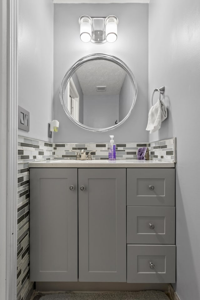 bathroom featuring tasteful backsplash, visible vents, and vanity