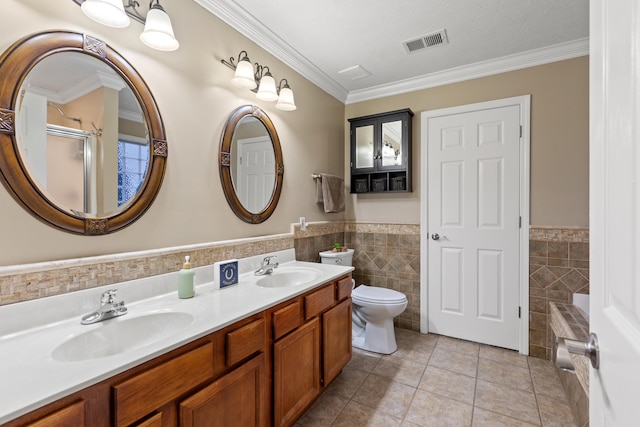 bathroom with tile patterned flooring, visible vents, a sink, and tile walls