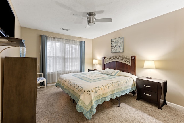 bedroom featuring a ceiling fan, light colored carpet, visible vents, and baseboards