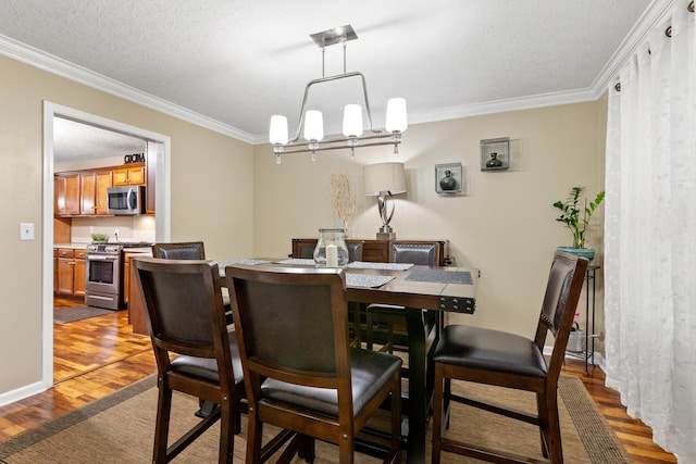 dining space with light wood-type flooring, ornamental molding, and a notable chandelier