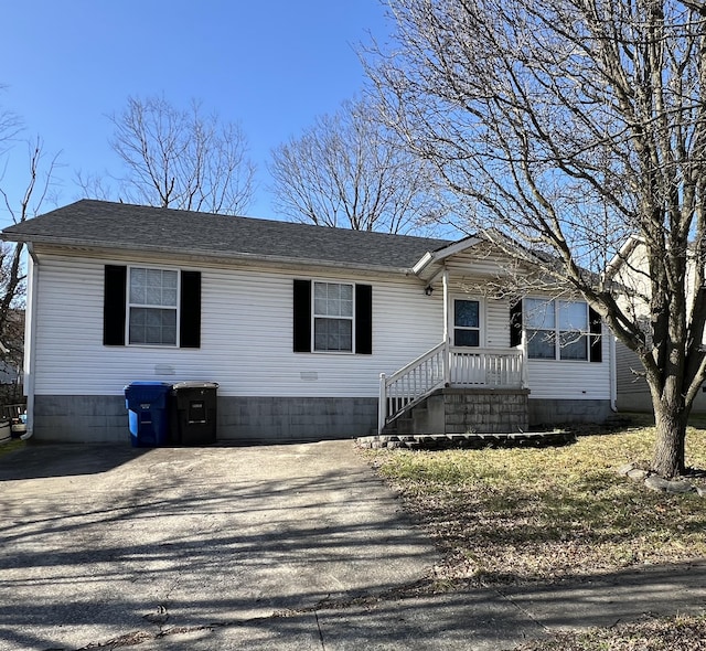 manufactured / mobile home with driveway and a shingled roof