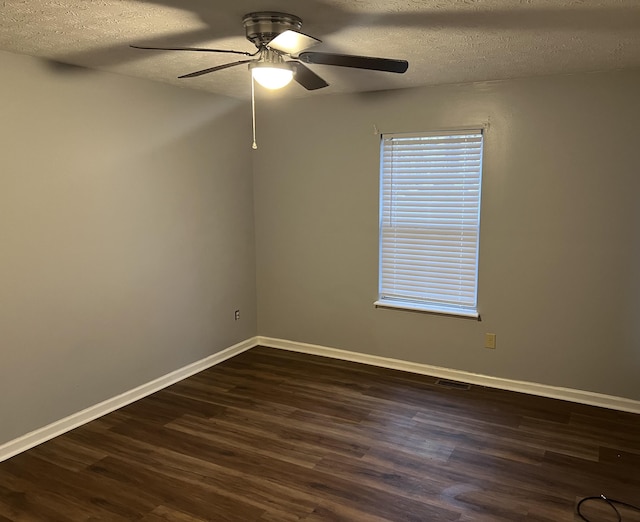 unfurnished room with baseboards, visible vents, ceiling fan, dark wood-type flooring, and a textured ceiling