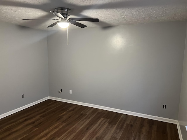 spare room with a textured ceiling, ceiling fan, dark wood-type flooring, and baseboards