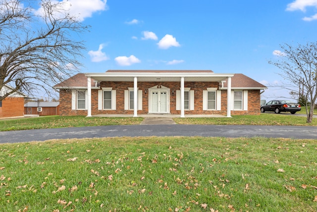 view of front of home featuring aphalt driveway, a front yard, and brick siding