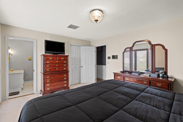 bedroom featuring a closet, visible vents, baseboards, and ensuite bathroom