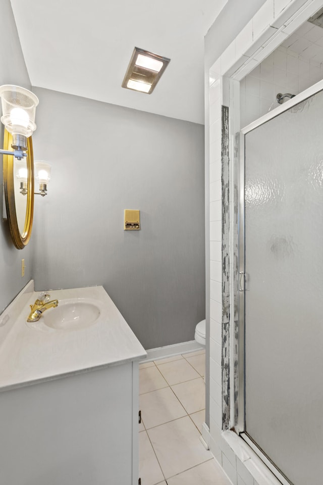 bathroom featuring a stall shower, tile patterned flooring, vanity, and toilet