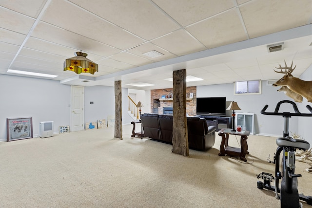 exercise area with carpet, a fireplace, a paneled ceiling, visible vents, and baseboards