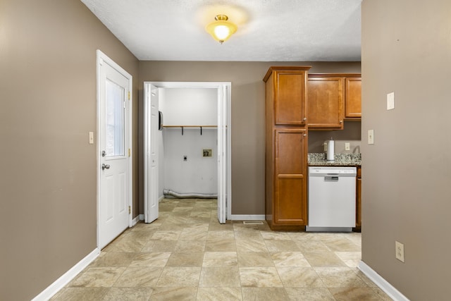 kitchen featuring brown cabinetry, dishwasher, and baseboards