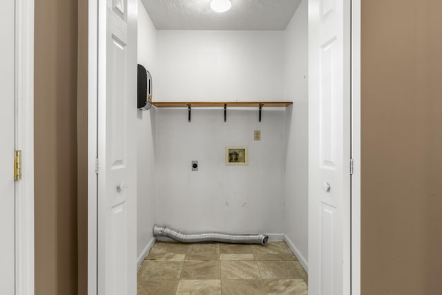 laundry area with washer hookup, electric dryer hookup, a textured ceiling, laundry area, and baseboards