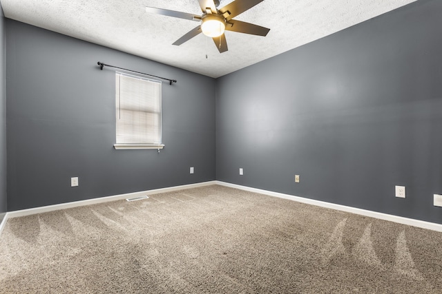 carpeted empty room featuring baseboards, visible vents, ceiling fan, and a textured ceiling