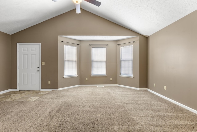 carpeted spare room with lofted ceiling, ceiling fan, a textured ceiling, and baseboards