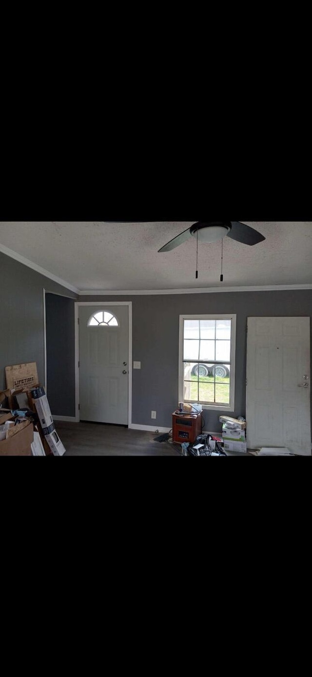 foyer with a textured ceiling, ornamental molding, and a ceiling fan