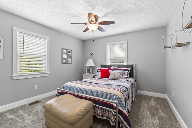 bedroom featuring baseboards, visible vents, dark colored carpet, and a textured ceiling