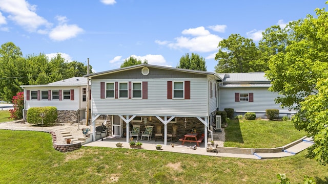 rear view of property featuring a patio and a lawn