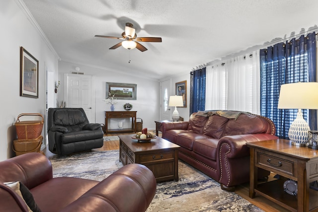 living area with light wood-style floors, a ceiling fan, vaulted ceiling, and a textured ceiling