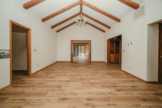 interior space with high vaulted ceiling, beam ceiling, visible vents, and light wood finished floors