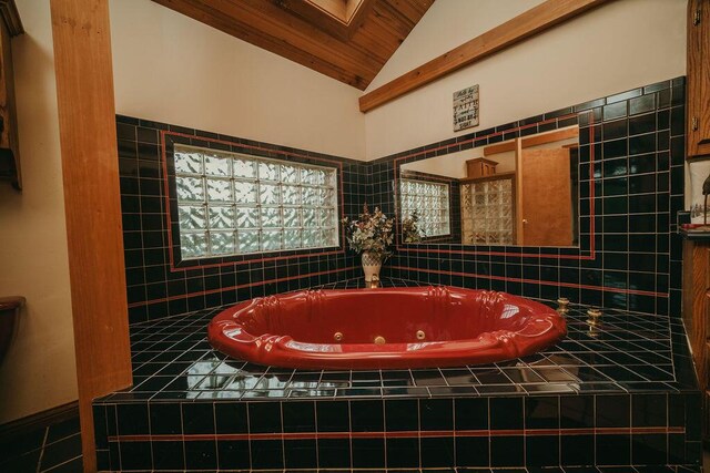 full bath featuring vaulted ceiling and a tub with jets