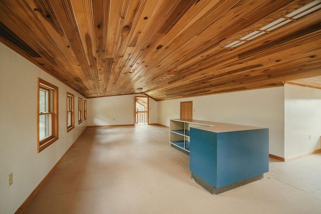 interior space with lofted ceiling, wooden ceiling, concrete flooring, and baseboards