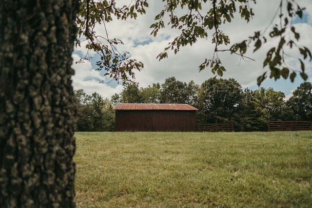 view of yard featuring a pole building, an outdoor structure, and fence