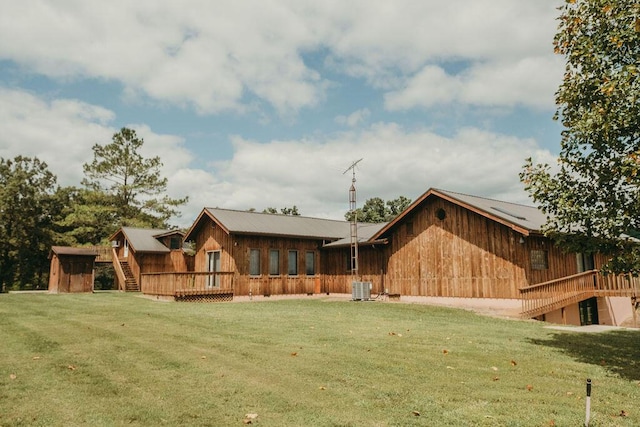 back of property featuring a yard, stairway, central AC, and a wooden deck