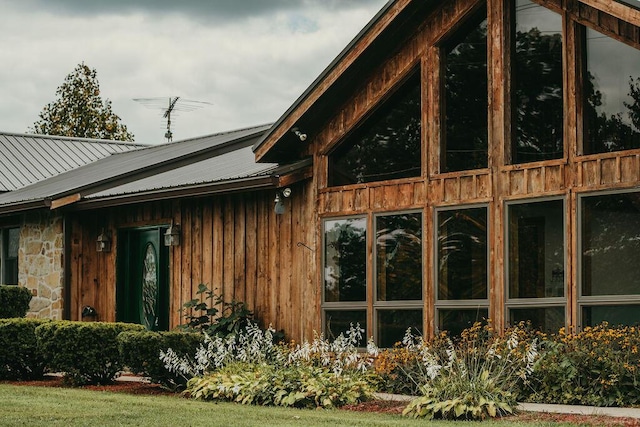 view of property exterior with stone siding and metal roof