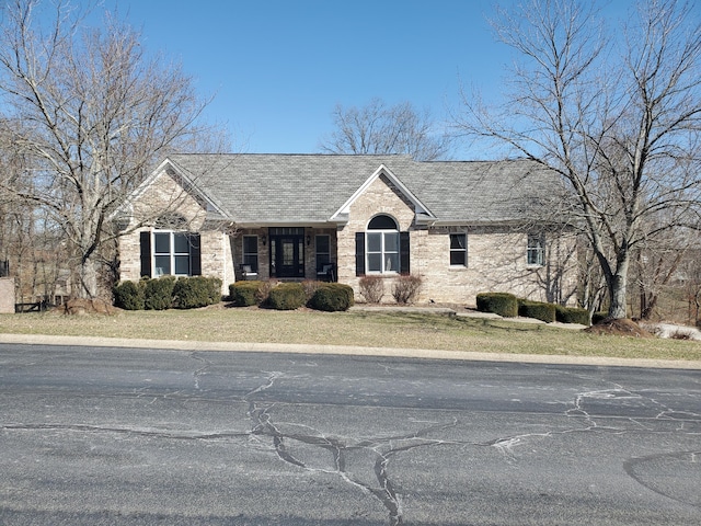 ranch-style home with roof with shingles