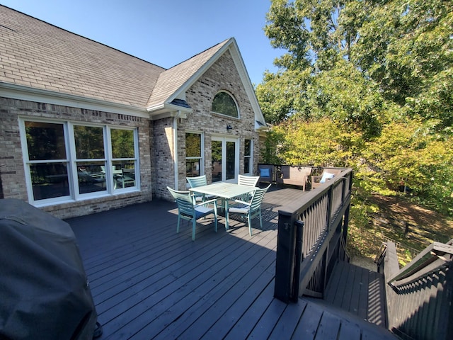 deck with outdoor dining area and grilling area