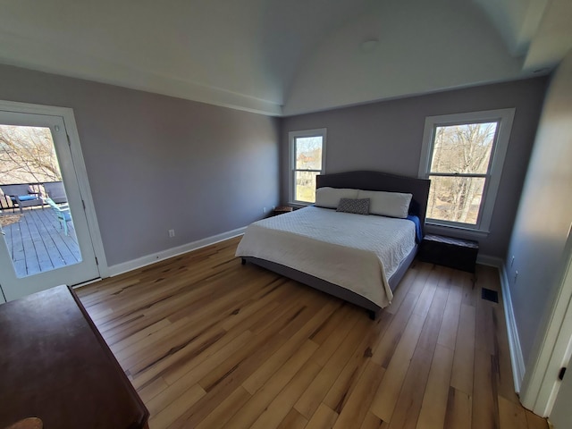 bedroom featuring access to outside, multiple windows, and wood-type flooring