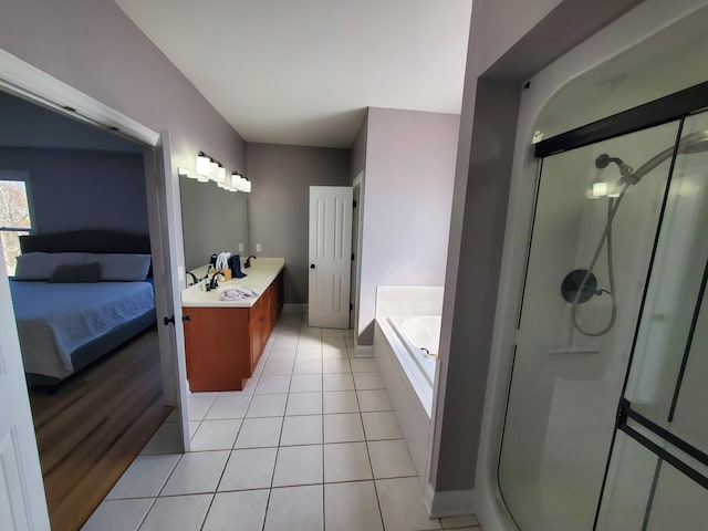 full bath with ensuite bathroom, a shower stall, vanity, tile patterned flooring, and a bath