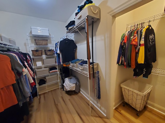 walk in closet with wood finished floors