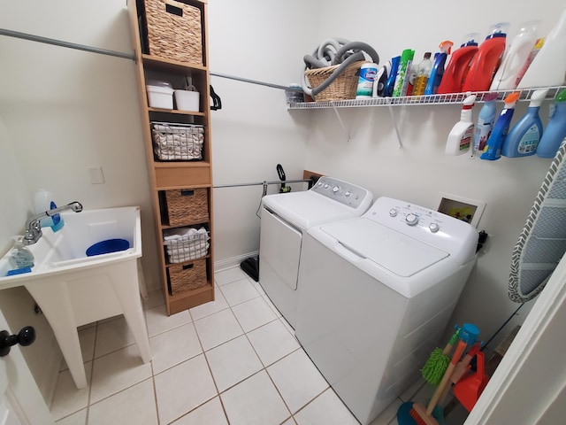 washroom featuring laundry area, light tile patterned floors, and washer and clothes dryer