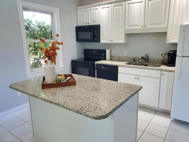 kitchen featuring a wealth of natural light, white cabinets, a sink, and black appliances