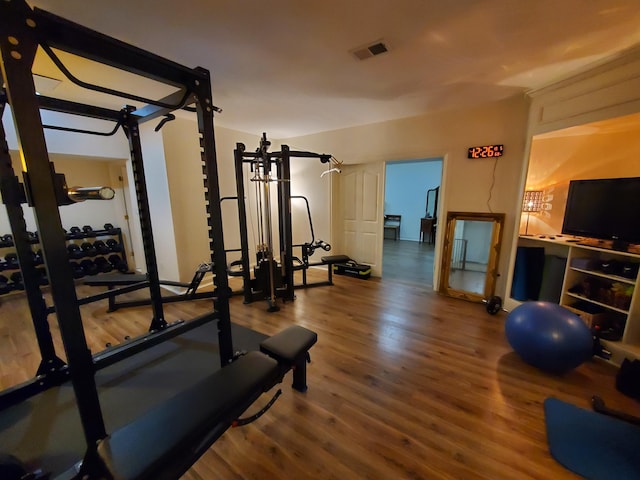 exercise room featuring wood finished floors and visible vents