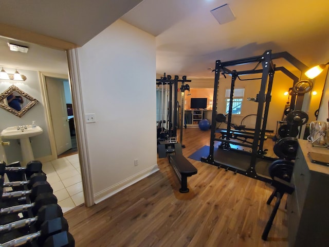 exercise area featuring baseboards and wood finished floors