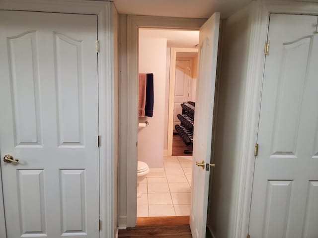 hallway with baseboards and light tile patterned floors