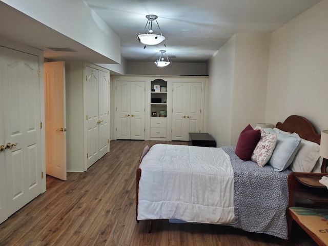 bedroom with visible vents and dark wood finished floors