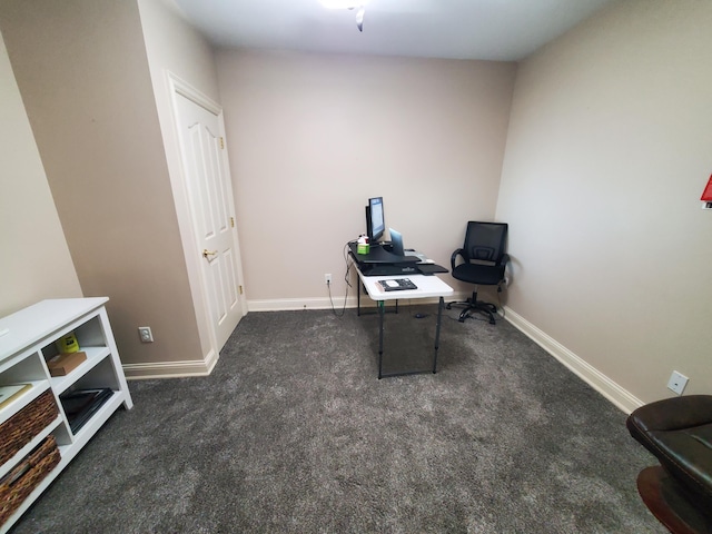 home office with baseboards and dark carpet