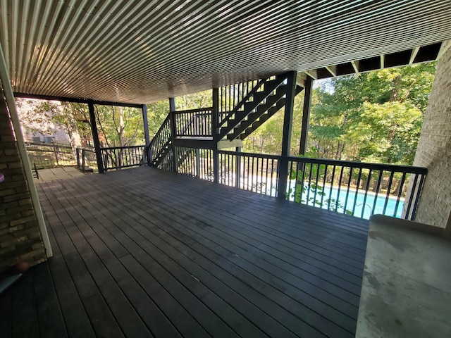 wooden deck featuring stairway and a fenced in pool