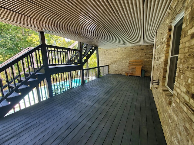 deck with stairway and a fenced in pool