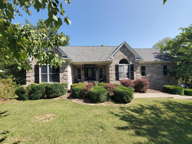 ranch-style house with a front yard and brick siding