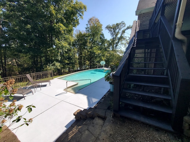 view of pool with a patio area, stairs, fence, and a fenced in pool