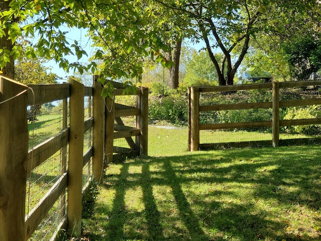 view of gate featuring a lawn and fence