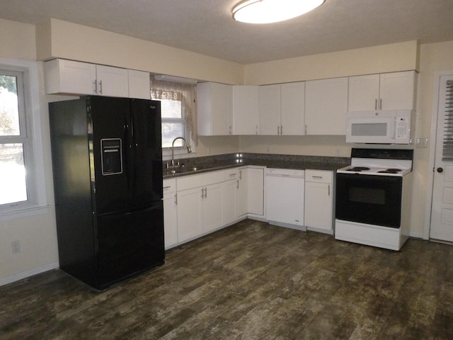 kitchen featuring dark countertops, white appliances, white cabinets, and dark wood finished floors