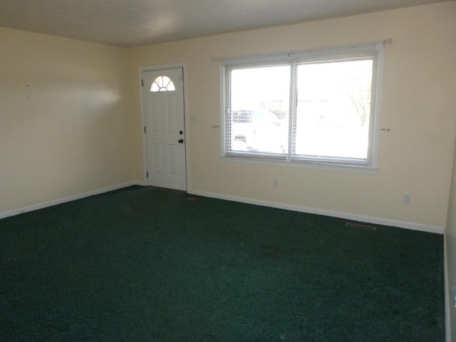 entryway featuring dark colored carpet and baseboards