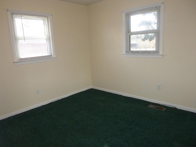 carpeted spare room with visible vents and baseboards