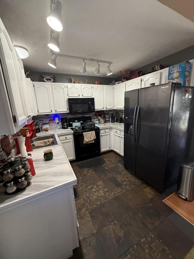 kitchen with tasteful backsplash, white cabinets, stone finish floor, light countertops, and black appliances