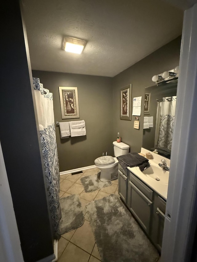 bathroom with toilet, a shower with curtain, tile patterned flooring, a textured ceiling, and vanity