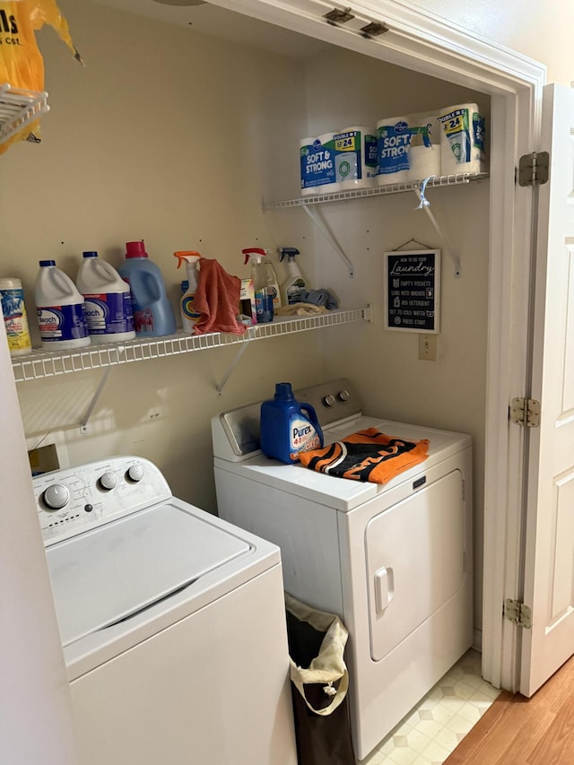 laundry area with laundry area, light wood finished floors, and washer and clothes dryer